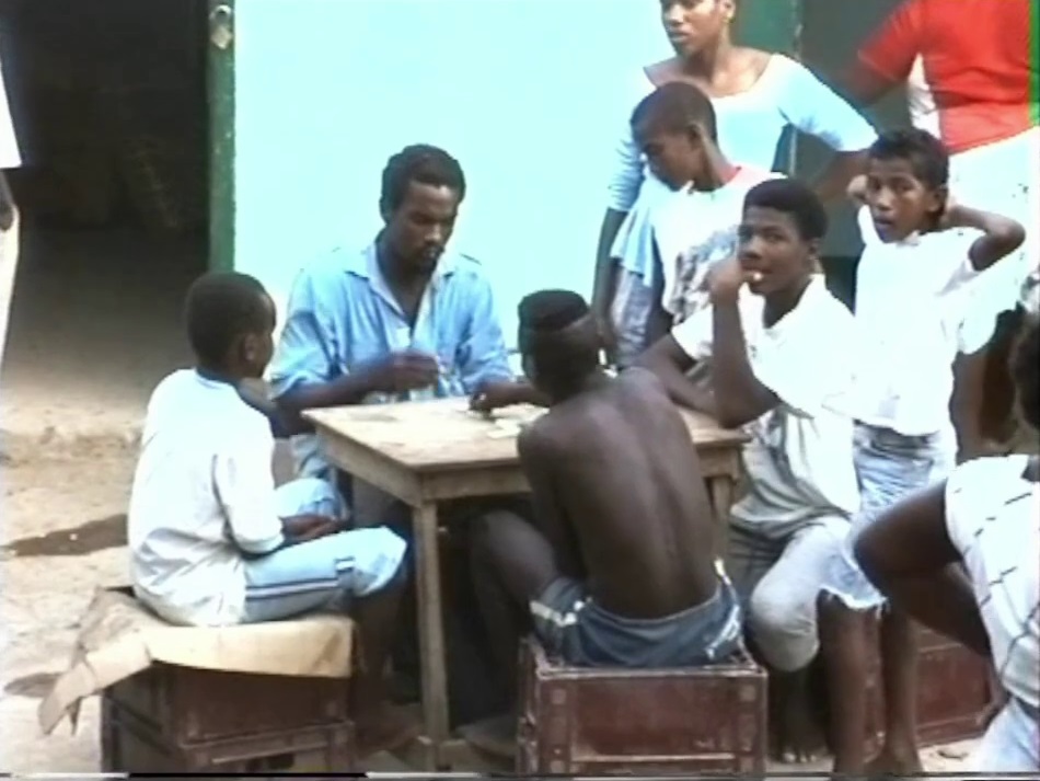 A group of locals relaxing in the evening by playing a game of Dominos in the street in Bottom House in Providencia.