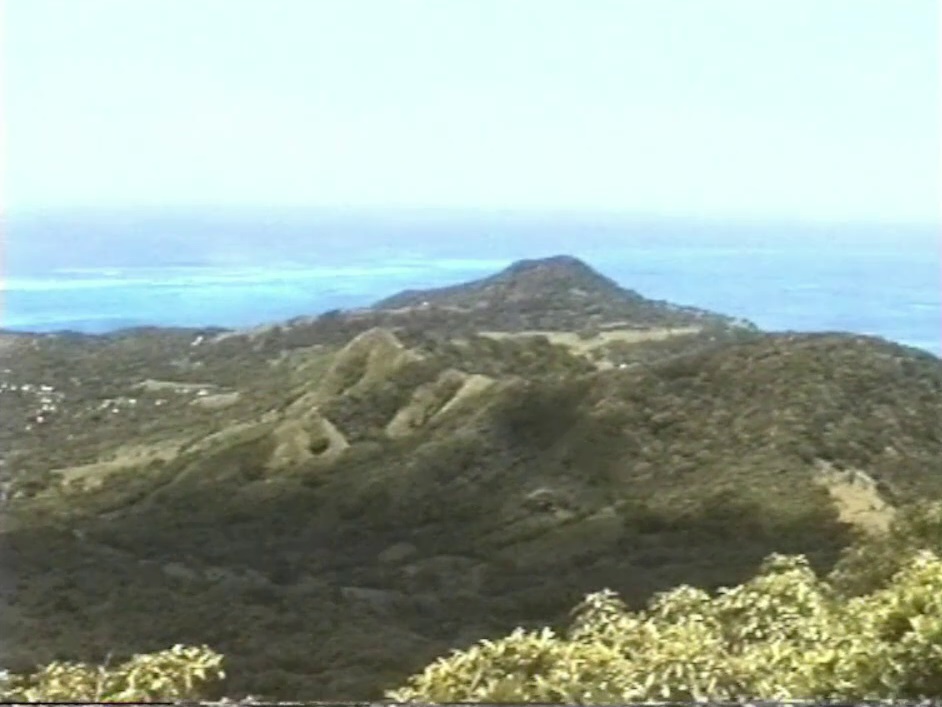 A view from The Peak, the highest point on Providencia, down over the hills to the sea and the coral reefs beyond.